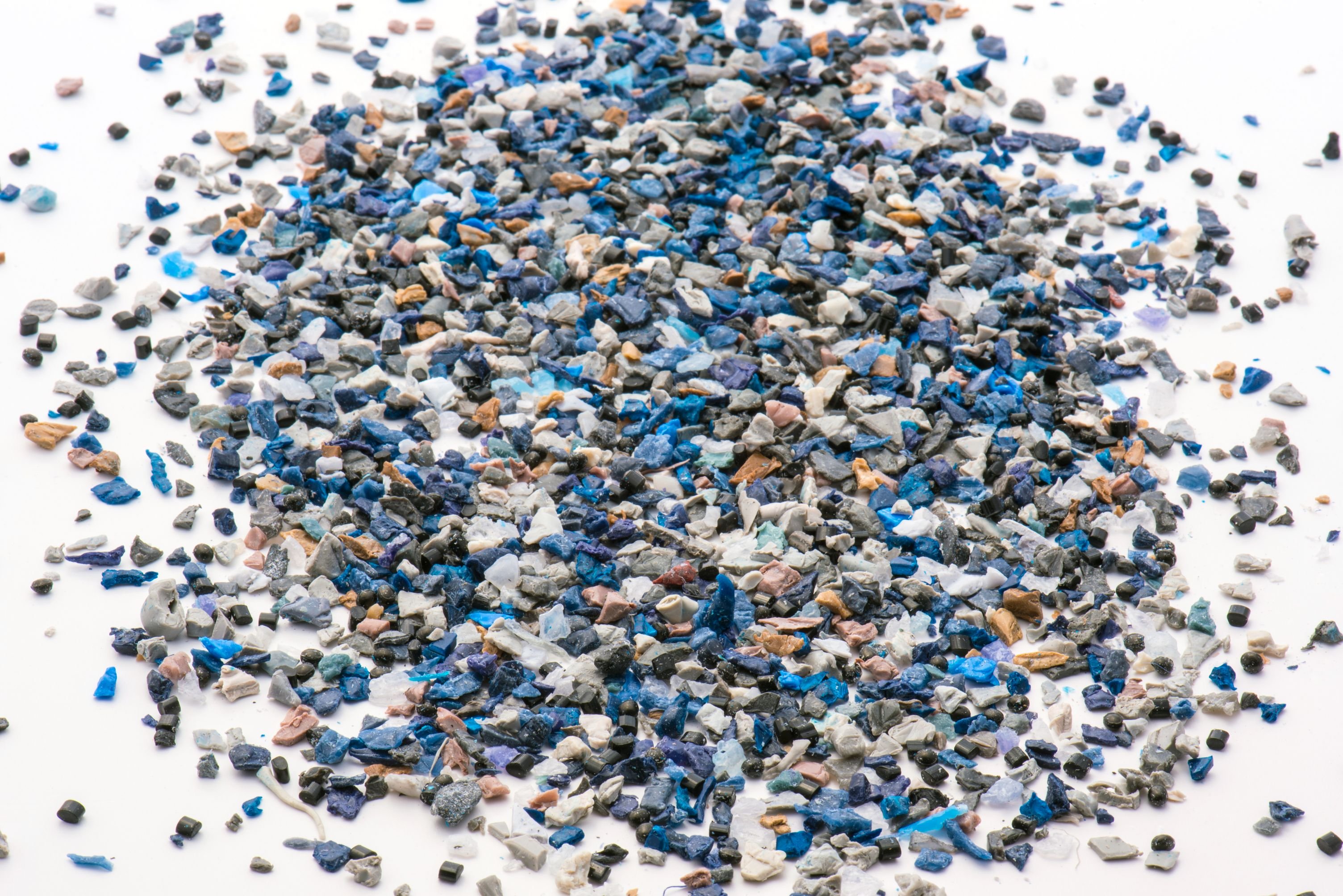 Plastiksteinchen auf weißer Fläche, Blautöne,  Türkis, Weiß, unregelmäßige Form und Oberfläche